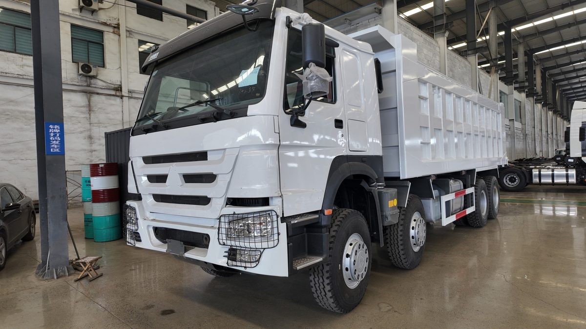 White HOWO 8x4 dump truck inside a factory workshop