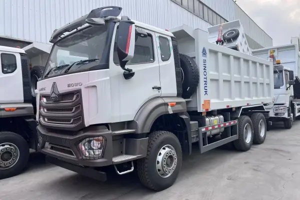 SINOTRUK HOWO NX 6×4 dump truck front three-quarter white studio view showing H77L cab and 5600 mm dump body.