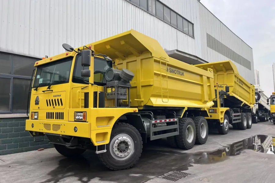Rear studio view of SINOTRUK HOWO Mining Dump Truck with reinforced tailgate and wide 3100 mm mining cargo box.